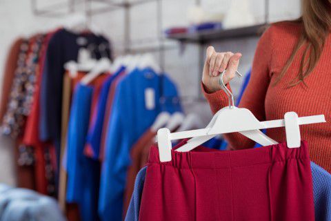 Woman preparing red dress for clothes bank